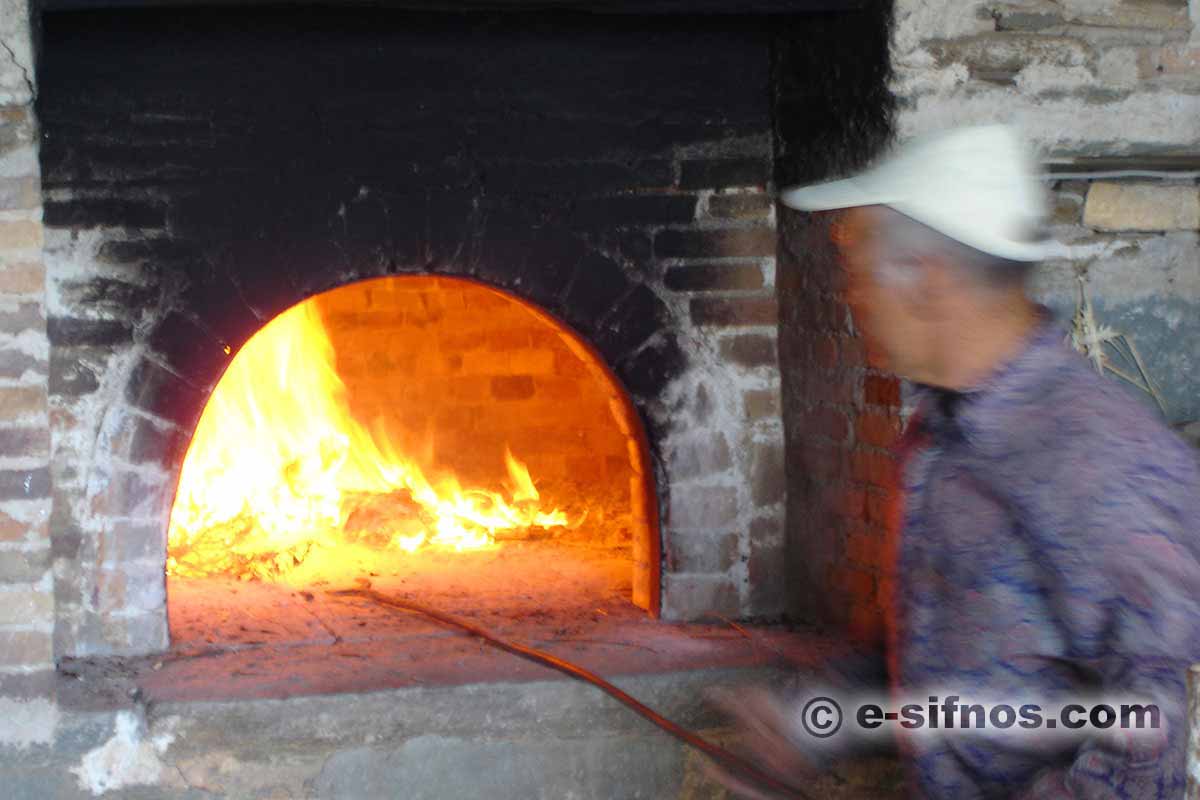 Preparing the wood-fired oven for mastelo at Easter in Sifnos